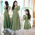 Avocado green satin Sisters Group Dress for women, featuring a flowing skirt and spring-inspired design by CJ.